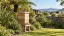 Illustrative beehive in an Auckland garden with native flax and tree ferns