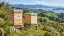 Illustration of timber beehives on a green New Zealand hillside
