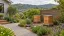 Illustration of closed timber beehives in a sheltered Wellington hillside garden